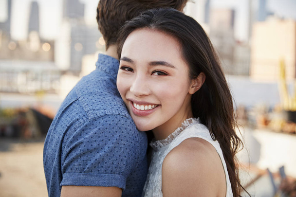 Romantic Couple On Rooftop Terrace With City Skyline In Background - 写真・画像