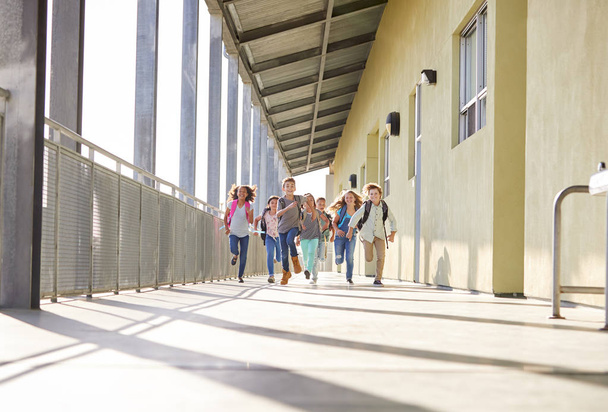 Group of elementary school kids running in a school corridor - Фото, зображення