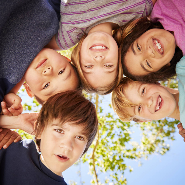 Five schoolchildren standing in circle and smiling - Fotó, kép