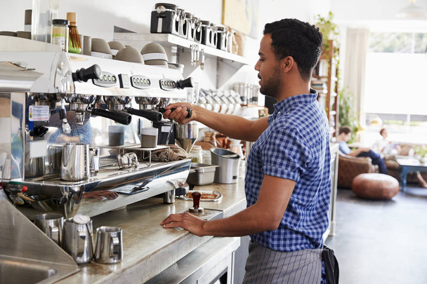 Young male barista preparing espresso at coffee shop - 写真・画像