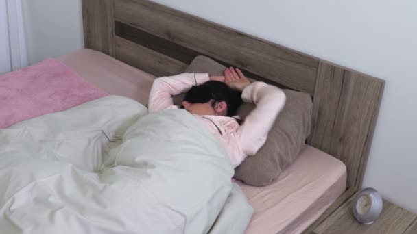 自宅のベッドでストレッチ マスクを睡眠の女性 - 映像、動画