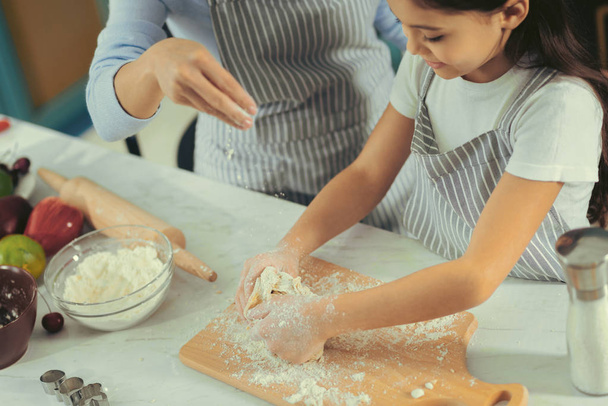 Cute little girl making a dough with mother - Foto, Imagen