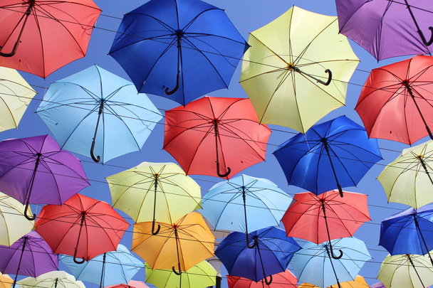 Colorido guarda-chuvas decoração urbana rua. Pendurado guarda-chuvas coloridos sobre o céu azul, turista
 - Foto, Imagem