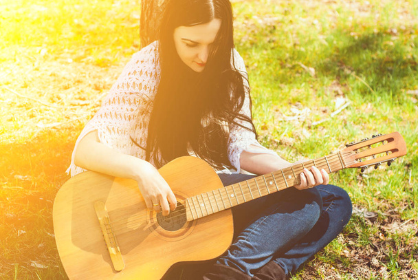 woman playing an acoustic guitar outdoor - Foto, Imagem