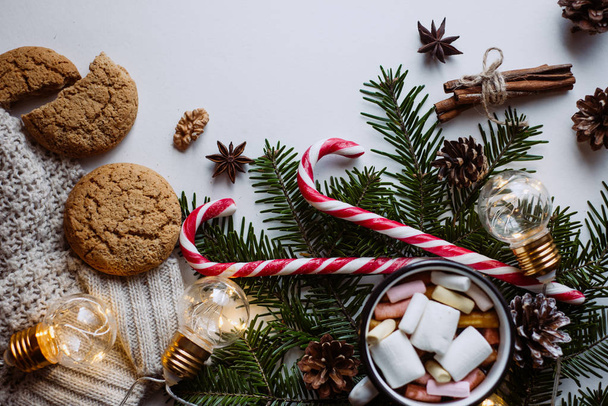 Chocolate or cocoa with marshmallow, cookies, candy and the garland on a dark background. - Photo, Image