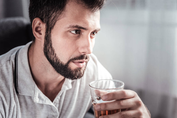 Portrait of an unhappy gloomy man drinking - Photo, image