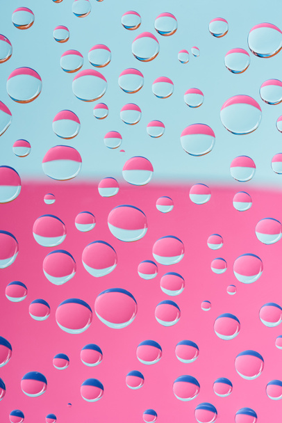 vista de cerca de gotas de agua transparentes sobre fondo abstracto rosa y azul
  - Foto, Imagen