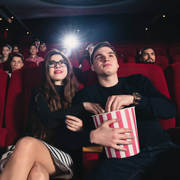 A couple in love flirting at the cinema and eating popcorn - Foto, imagen