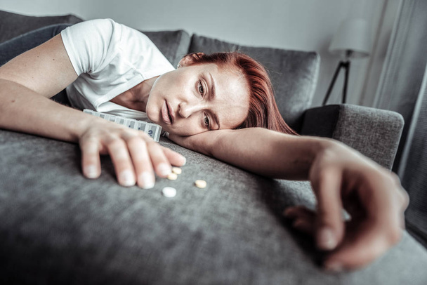 Sick female person looking at pills - Фото, зображення