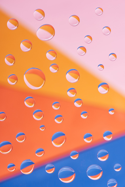 close-up view of transparent calm water drops on colorful background            - Fotografie, Obrázek