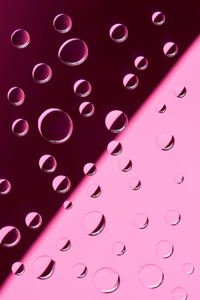 vista de cerca de gotas de rocío transparente sobre fondo rosa
         - Foto, Imagen