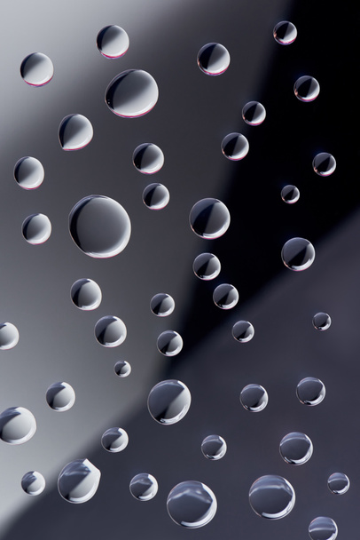 close-up view of transparent droplets on dark background  - Valokuva, kuva