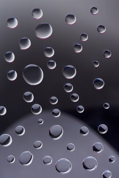 close-up view of transparent water drops on dark background  - Foto, afbeelding