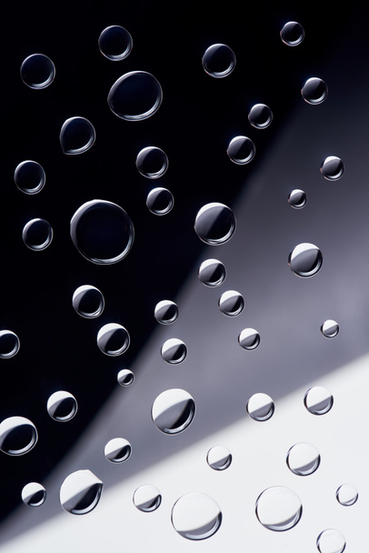 close-up view of transparent water drops on black, grey and white background - Valokuva, kuva