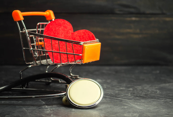 Red heart in a supermarket trolley and stethoscope. The concept of medicine and health insurance, family, life. Ambulance. Cardiology Healthcare. - Foto, Bild