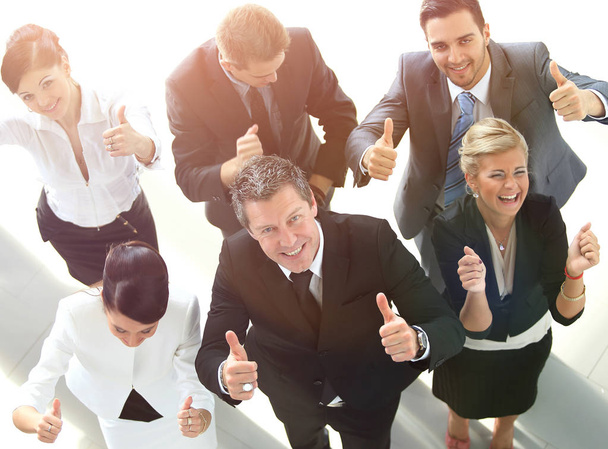 view from the top. happy business team showing thumb up. - 写真・画像