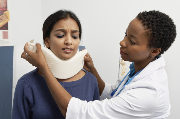 Female Doctor Putting Brace On Patient's Neck - Photo, Image