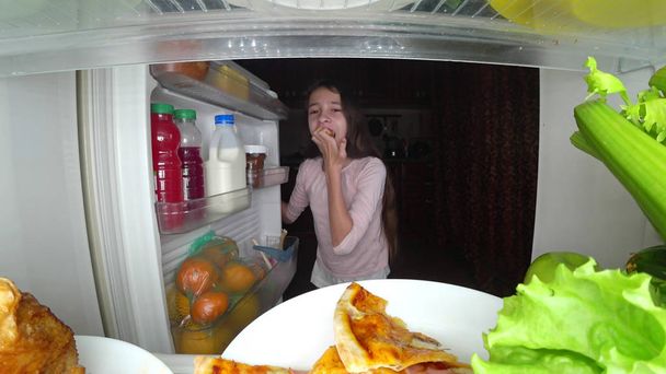 Tyttö teini avaa jääkaapin yöllä. yöllinen nälkä. ruokavalion ahmiminen
 - Valokuva, kuva