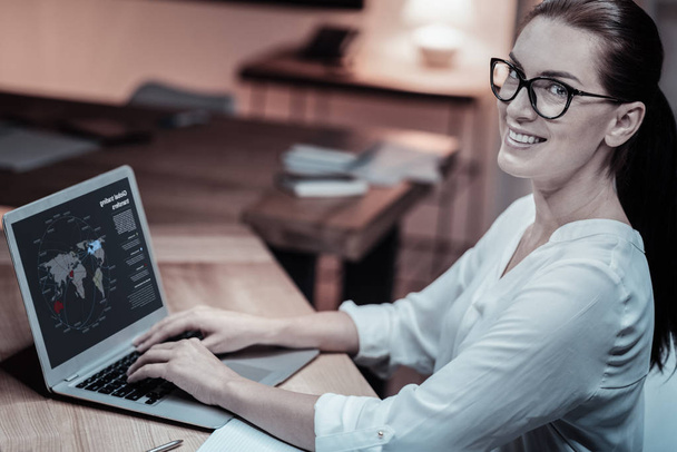 Positive delighted female working with laptop - Photo, Image