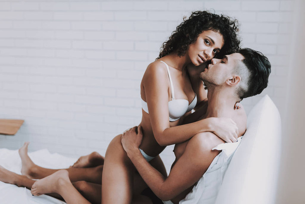 Young Beautiful Couple in Underwear Lying on Bed. Handsome Man Kissing Attractive Woman. Passionate Romantic Couple about to have Sex at Home. Passion, Intimate Relationship and Love Concept - Foto, Imagem