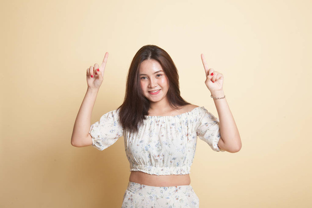 Young Asian woman point to blank space on beige background - Φωτογραφία, εικόνα