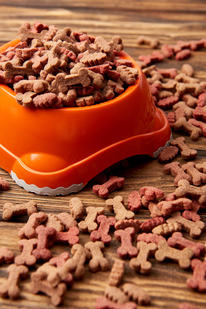close up view of plastic bowl with pile of dog food on wooden table  - Photo, Image