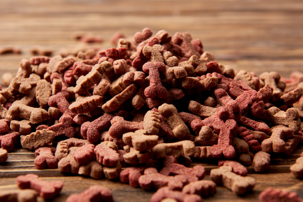 selective focus of pile of dog food on wooden table  - Фото, изображение