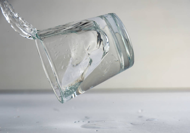 falling, flying or standing glass with a clear liquid intended for vodka and splash of liquid - Foto, Bild