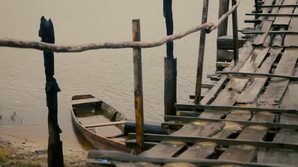 alte rustikale Brücke und halb versunkenes Holzboot an einem regnerischen Tag - Filmmaterial, Video