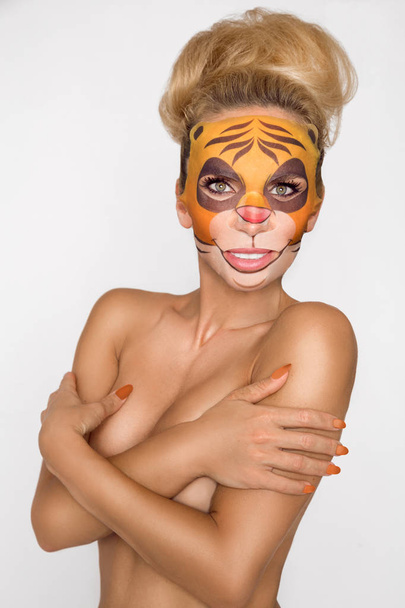 Beautiful woman with moisturizing leopard face mask. Mask with leopard, cat. - Photo, Image