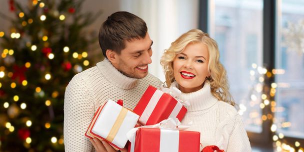 happy couple with christmas gifts at home - Foto, Imagen