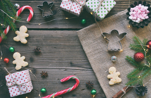 Χριστουγεννιάτικη σύνθεση με μπισκότα, μελόψωμο μπαχαρικά, marshmallows, εορταστική διακόσμηση, καραμέλα και έλατα κλαδί δέντρου. Προετοιμασία για το ψήσιμο των διακοπών. Το νέο έτος, Χριστούγεννα έννοια. Κάτοψη, με αντίγραφο χώρου - Φωτογραφία, εικόνα