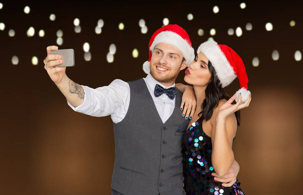 couple in santa hats aking selfie at christmas - Foto, immagini