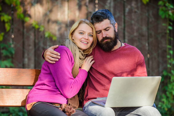 Couple with laptop sit bench in park nature background. Surfing internet together. Family surfing internet for interesting content. Internet surfing concept. Couple in love notebook consume content - Фото, зображення