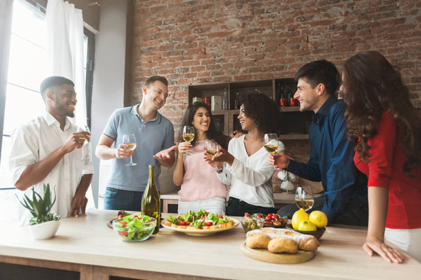 Amici eccitati che bevono e chattano in cucina
 - Foto, immagini