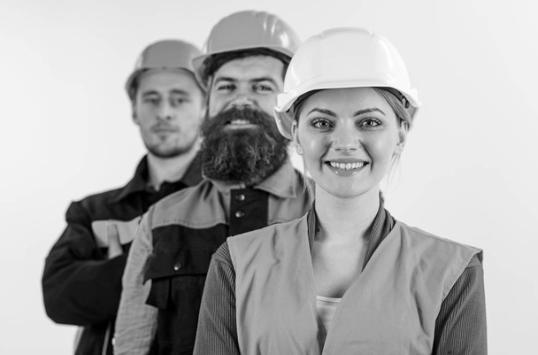 Woman and men in hard hats stand close as team. - Fotografie, Obrázek