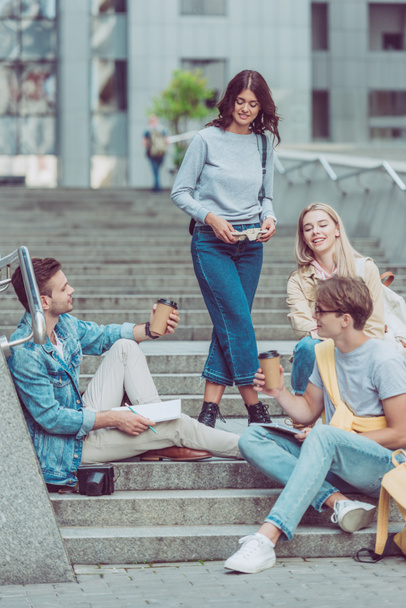 friends with coffee to go resting on street steps in new city - Fotografie, Obrázek