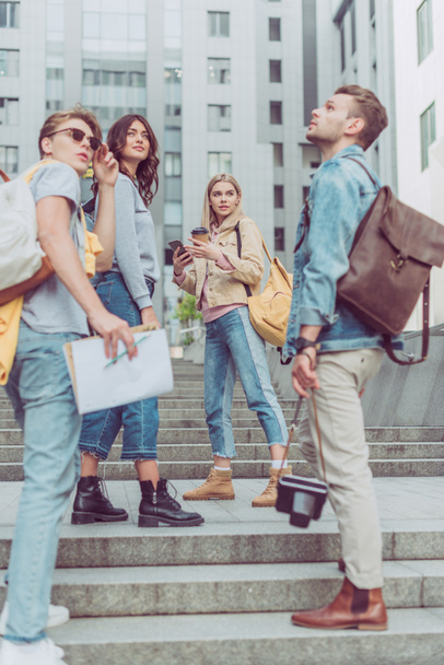 Gruppe junger Touristen mit Rucksäcken steht auf der Straße in der neuen Stadt - Foto, Bild