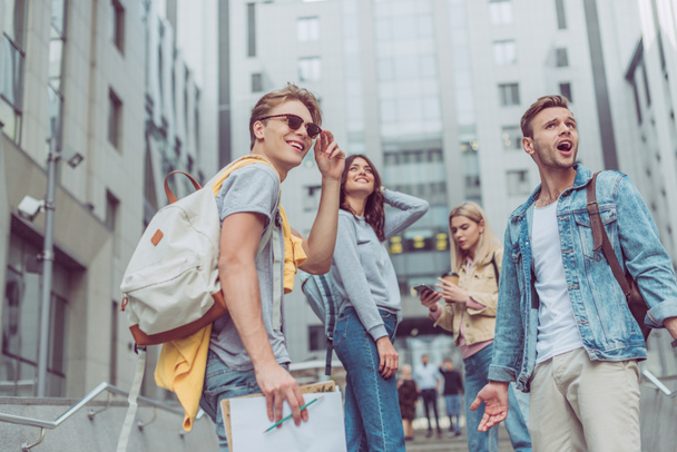 group of young tourists with backpacks standing on street in new city - Fotoğraf, Görsel