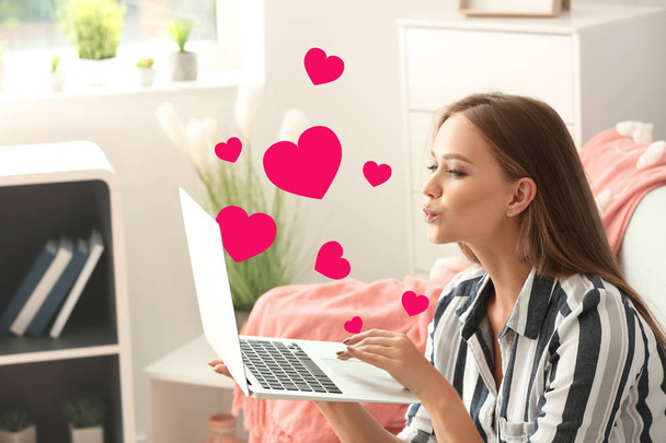 Молода жінка використовує ноутбук для онлайн знайомств вдома
 - Фото, зображення