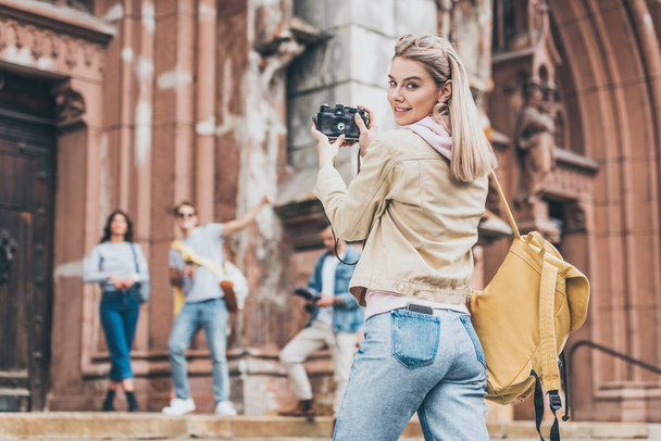 onnellinen tyttö ottaa valokuvan ystävistä kameran edessä kaupungissa
 - Valokuva, kuva