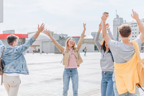 young happy travelers waving and walking in city   - Valokuva, kuva