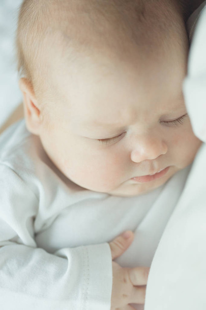 Yeni doğan bebek bir üst kollarında uyuyor. Bebek portresi. yumuşak renkli. - Fotoğraf, Görsel