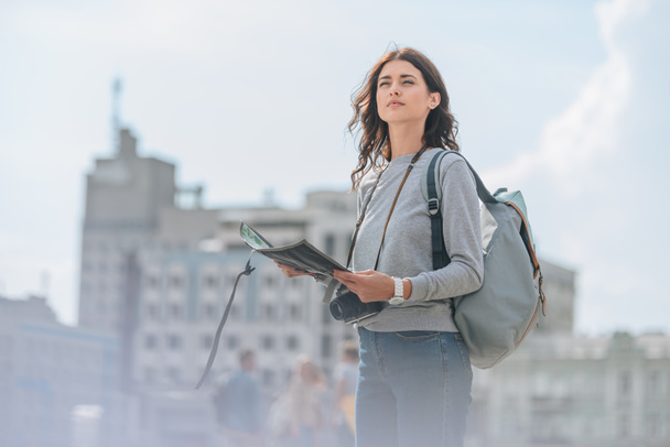 atraente turista feminino com câmera fotográfica, mochila e mapa caminhando na cidade
 - Foto, Imagem