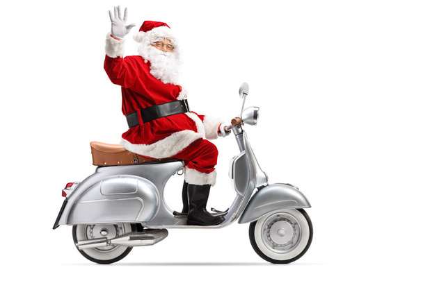 Full length profile shot of Santa Claus riding a vintage motorbike and waving isolated on white background - Photo, Image