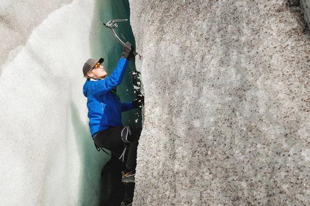 Δωρεάν ο ορειβάτης χωρίς ασφάλιση με δύο άξονες πάγου αυξάνεται από μια ρωγμή στον παγετώνα. Δωρεάν αναρρίχηση χωρίς σχοινιά - Φωτογραφία, εικόνα
