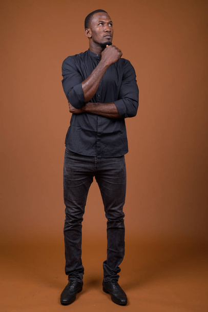 Retrato del guapo empresario africano sobre fondo marrón
 - Foto, Imagen