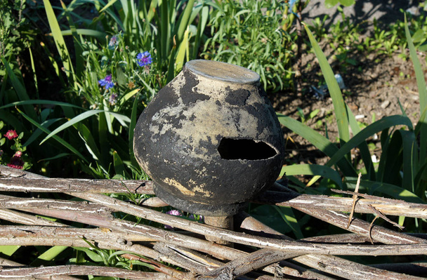Un vieux pot d'argile vintage sur une clôture en bois dans le village ukrainien
 - Photo, image