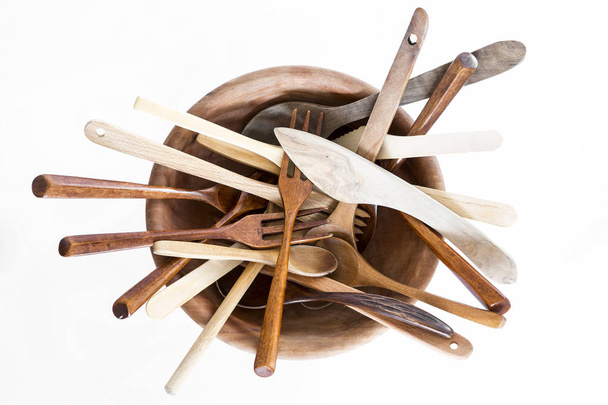 Wooden bowl with spoons and forks on a white background. Studio shot. Set of kitchen utensil. - 写真・画像