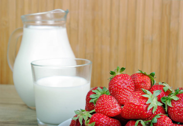 клубника и молоко на деревянном фоне
 - Фото, изображение
